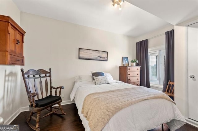 bedroom with baseboards and dark wood-style flooring