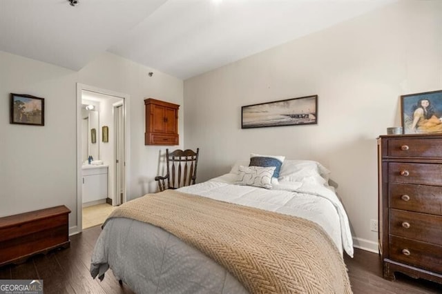 bedroom with baseboards, dark wood finished floors, and ensuite bathroom