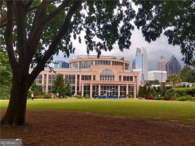 rear view of house with a city view and a lawn