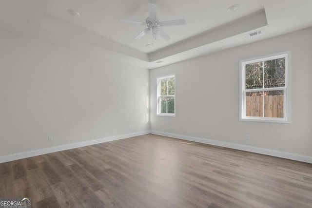 2005 Washington St, Savannah, GA 31406 - unfurnished room featuring a tray ceiling, wood finished floors, baseboards, and a ceiling fan