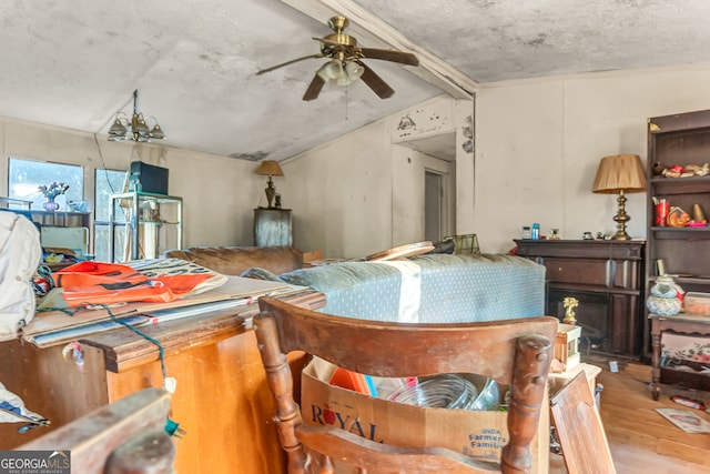 living room featuring vaulted ceiling with beams, wood-type flooring, and ceiling fan with notable chandelier