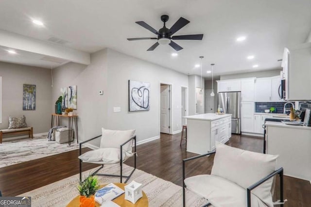 dining space with ceiling fan, sink, and dark wood-type flooring