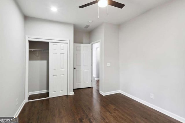 unfurnished bedroom featuring ceiling fan, a closet, and dark wood-type flooring