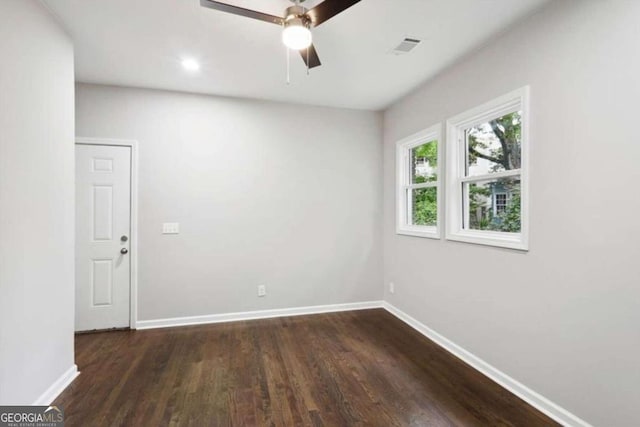 empty room with dark hardwood / wood-style flooring and ceiling fan