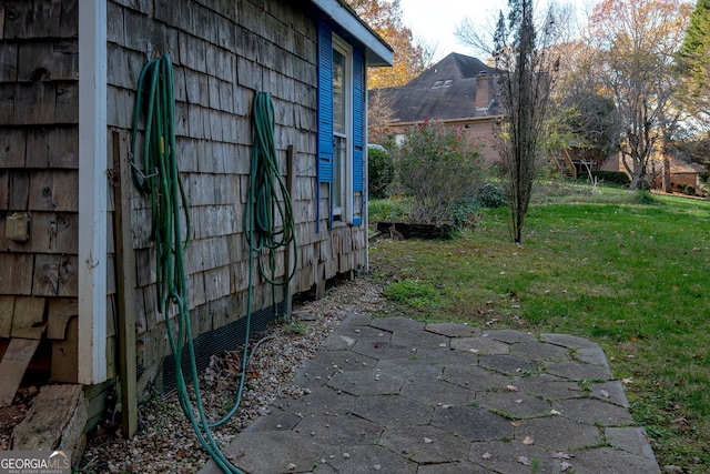 view of side of home with a patio area and a yard