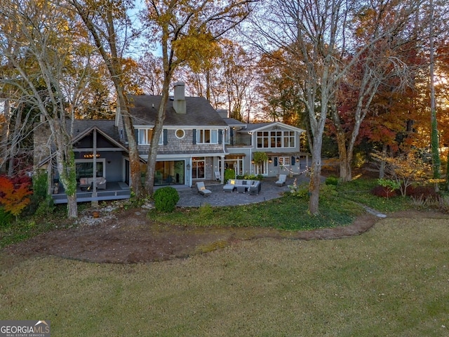 back of house with a lawn and a patio area