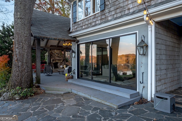 patio terrace at dusk with an outdoor stone fireplace