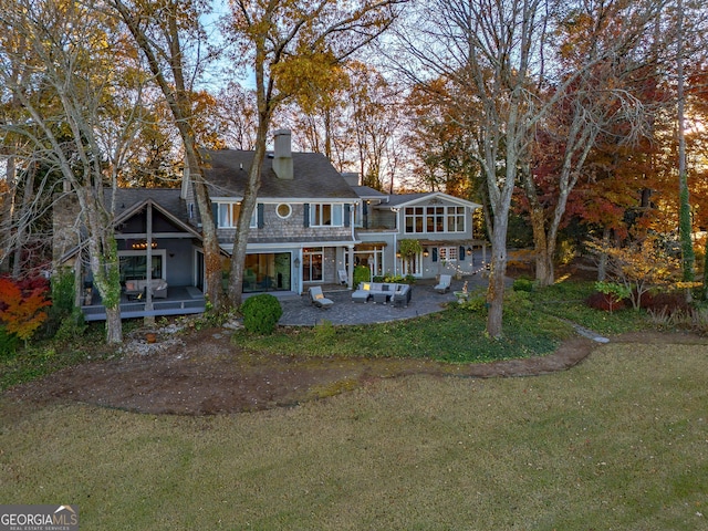 back of house featuring a lawn and a patio area