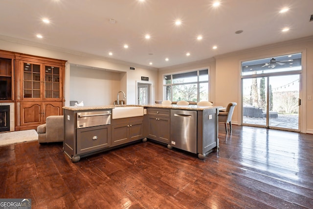 kitchen with dishwasher, a kitchen island with sink, sink, dark hardwood / wood-style floors, and light stone countertops