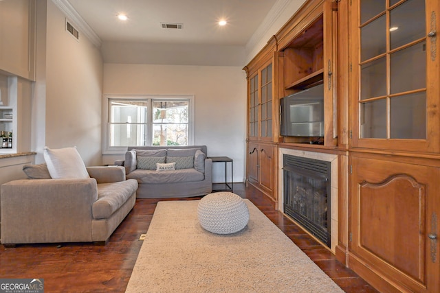 living room featuring crown molding, a fireplace, and dark hardwood / wood-style floors