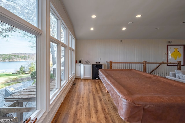 playroom featuring plenty of natural light, light hardwood / wood-style floors, a water view, and pool table