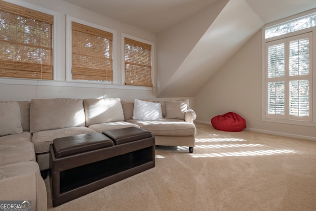 carpeted living room featuring a wealth of natural light and vaulted ceiling