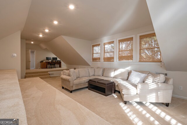 living room featuring light colored carpet and vaulted ceiling