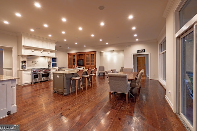 dining room featuring crown molding, sink, and dark hardwood / wood-style floors