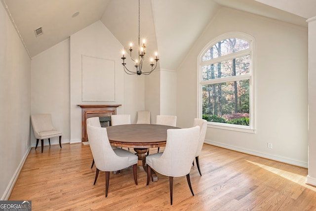 dining area featuring a chandelier, light hardwood / wood-style floors, and lofted ceiling