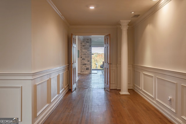 hall featuring decorative columns, hardwood / wood-style flooring, and ornamental molding