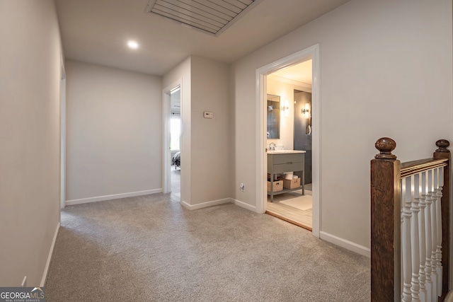 corridor featuring light colored carpet