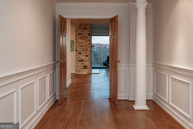 hallway with ornate columns, crown molding, and dark hardwood / wood-style flooring