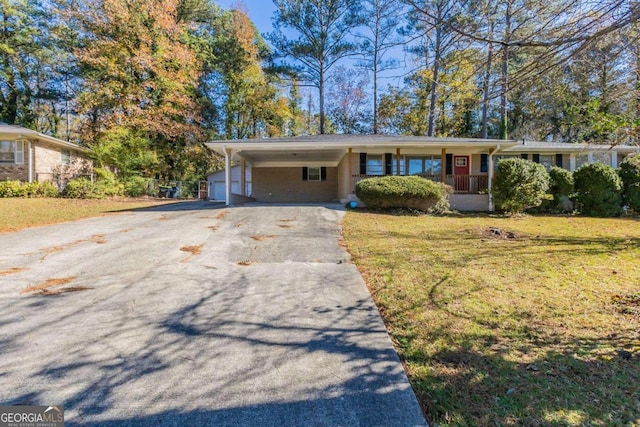 single story home featuring covered porch, a carport, and a front yard