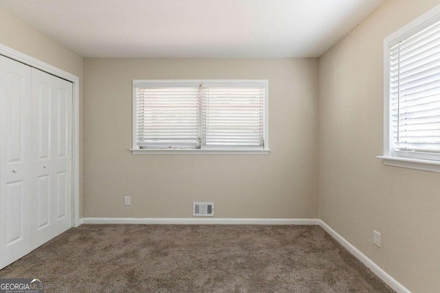 unfurnished bedroom featuring carpet flooring and a closet