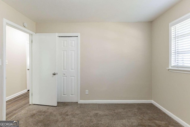 unfurnished bedroom with carpet flooring and a closet