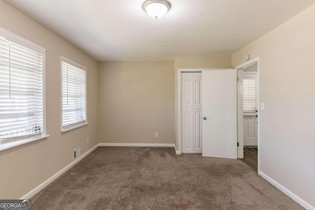 unfurnished bedroom featuring carpet flooring and a closet