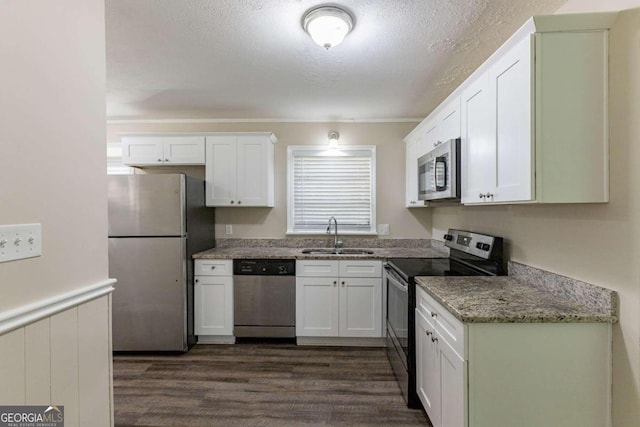 kitchen featuring sink, dark hardwood / wood-style floors, appliances with stainless steel finishes, stone countertops, and white cabinetry