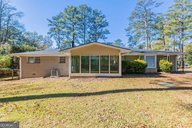 back of house featuring a lawn, a sunroom, and central AC