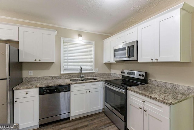 kitchen with dark hardwood / wood-style flooring, stainless steel appliances, white cabinetry, and sink