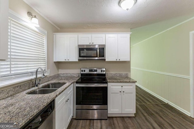 kitchen with white cabinets, appliances with stainless steel finishes, and sink