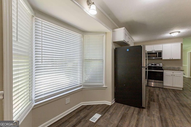 kitchen with dark hardwood / wood-style flooring, white cabinetry, and stainless steel appliances