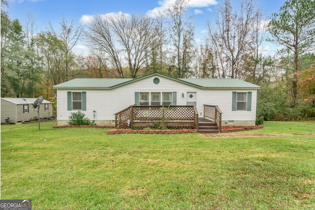 back of property featuring a wooden deck and a lawn