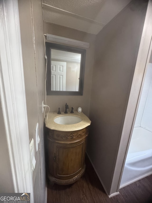 bathroom with vanity, wood-type flooring, and a textured ceiling