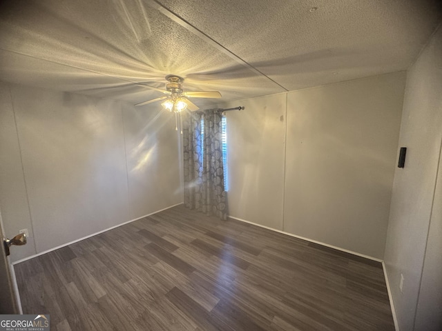 empty room with ceiling fan, dark hardwood / wood-style flooring, and a textured ceiling