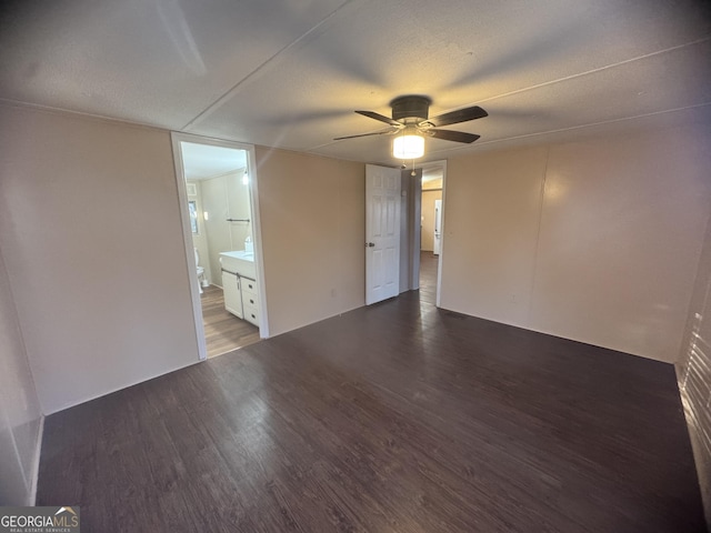 empty room featuring a textured ceiling, ceiling fan, and dark wood-type flooring