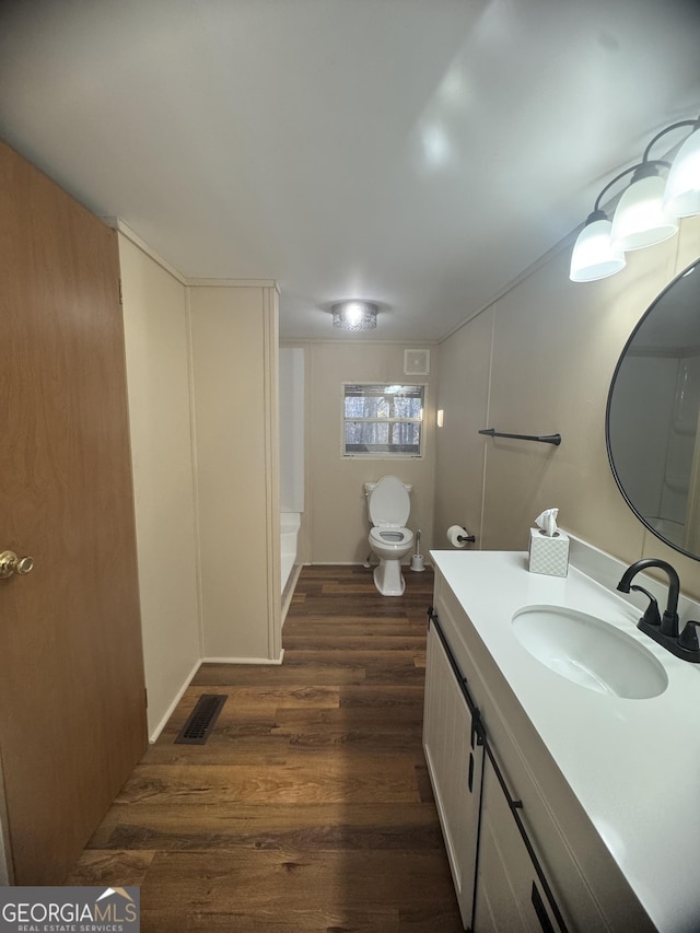 bathroom featuring hardwood / wood-style flooring, vanity, and toilet