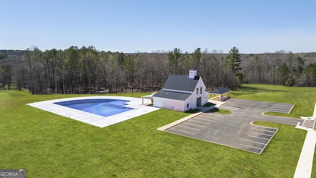pool featuring a view of trees and a lawn