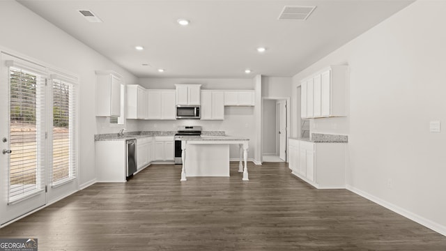 kitchen with white cabinets, plenty of natural light, a kitchen island, and stainless steel appliances