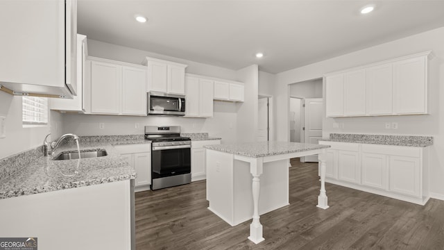 kitchen with white cabinets, sink, a center island, and appliances with stainless steel finishes