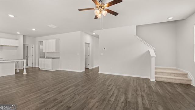 unfurnished living room with ceiling fan and dark wood-type flooring