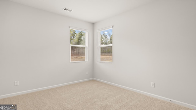 unfurnished room featuring light colored carpet