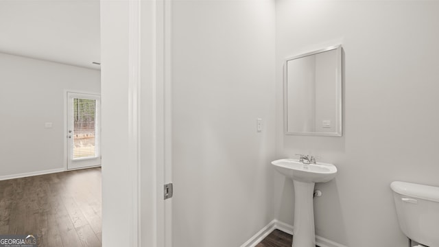 bathroom with hardwood / wood-style flooring and toilet