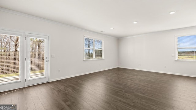 empty room with dark wood-style flooring, baseboards, ornamental molding, and recessed lighting