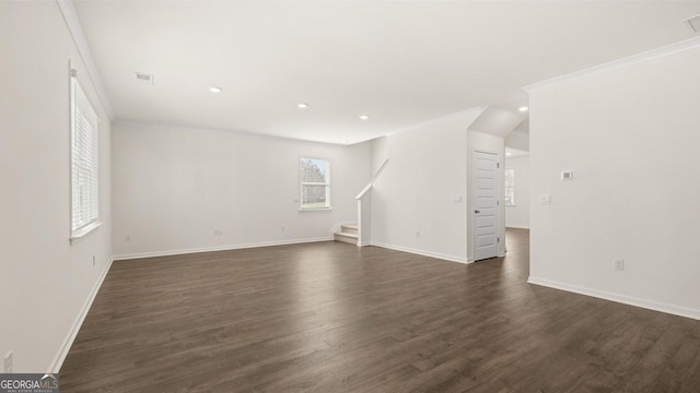 unfurnished living room with dark wood-style flooring, ornamental molding, and stairway