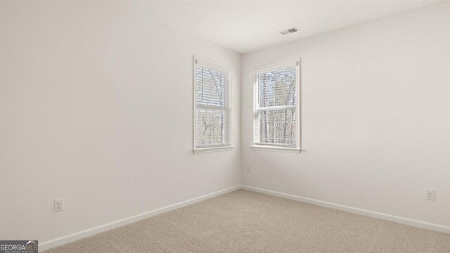 unfurnished room with baseboards, visible vents, and carpet floors