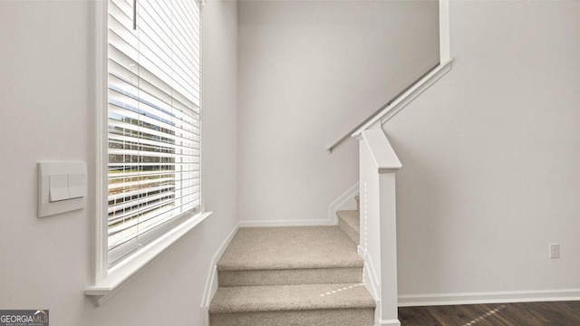 stairs featuring wood finished floors and baseboards