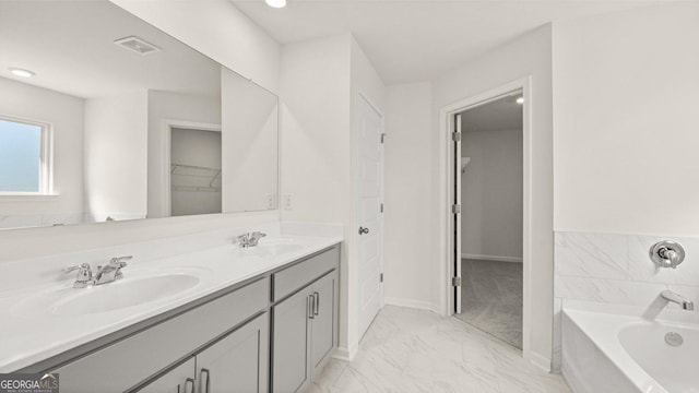 full bath featuring a bath, marble finish floor, a sink, and visible vents