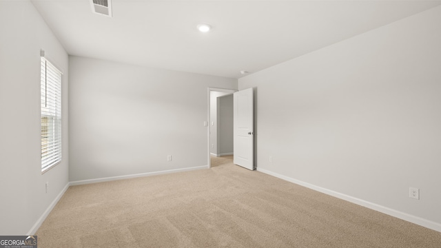 unfurnished room with a healthy amount of sunlight and light carpet