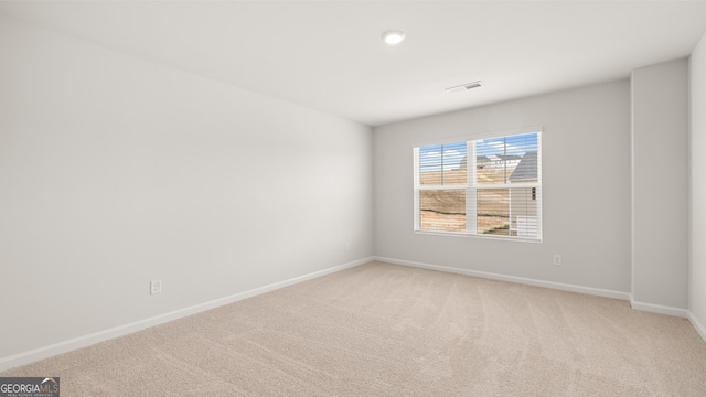 spare room featuring light colored carpet