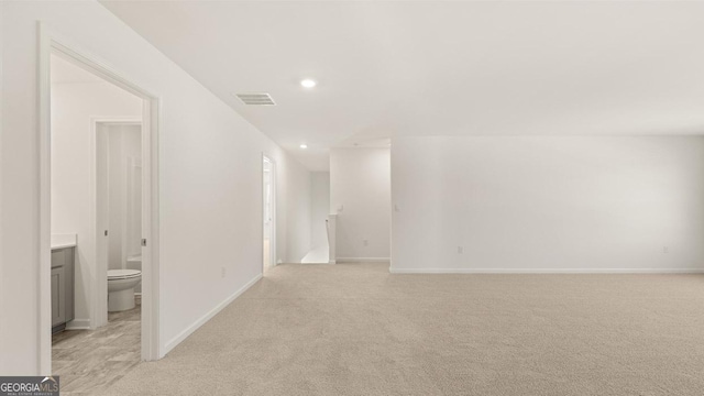 empty room featuring visible vents, baseboards, recessed lighting, and light colored carpet